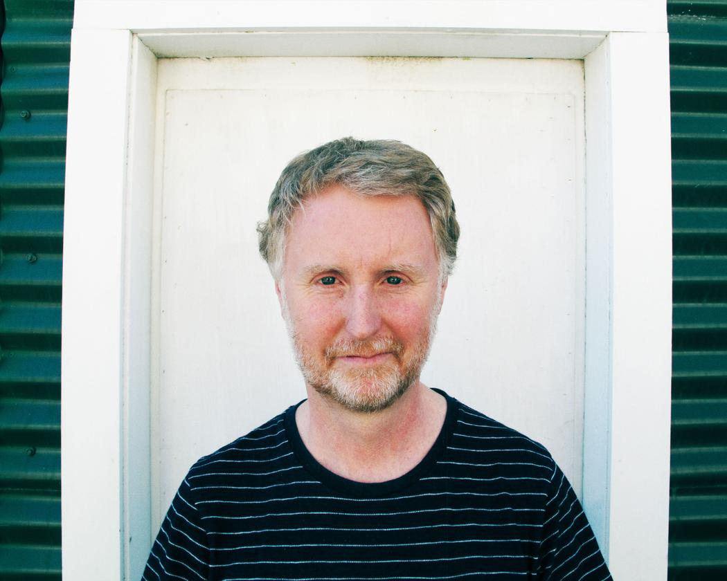 A man standing in front of a white door.